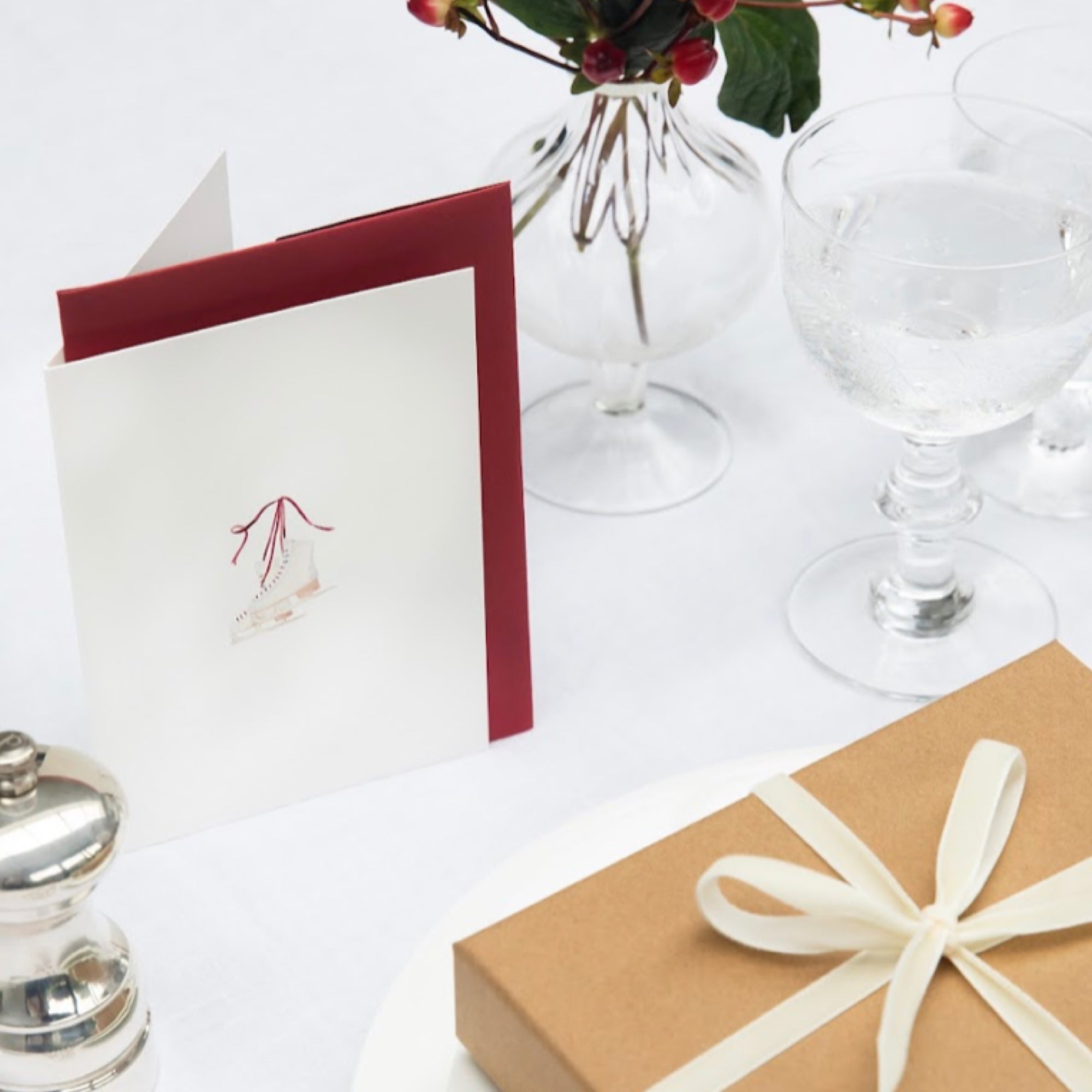 Luxury Christmas Card by Memo Press with a watercolour illustration of a pair of ice skates comes with a scarlet red envelope made in Britain