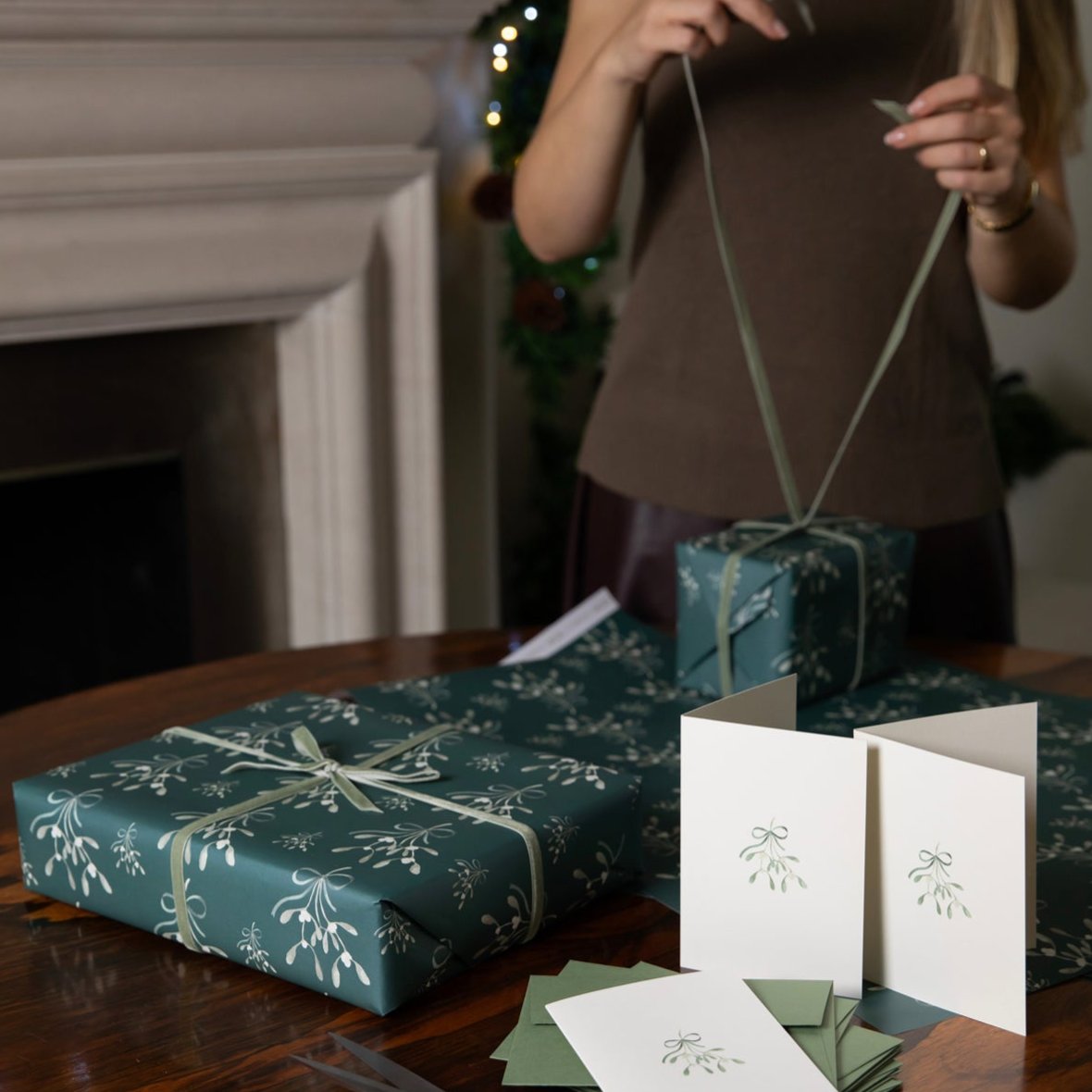 Luxury Christmas Card by Memo Press with a watercolour illustration of mistletoe tied with a ribbon tied with a bow and comes with a green envelope made in Britain