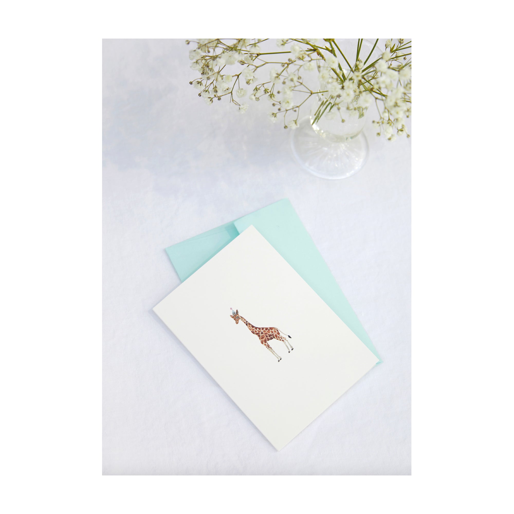 Greetings Card with a watercolour illustration of a giraffe in a party hat by Memo Press