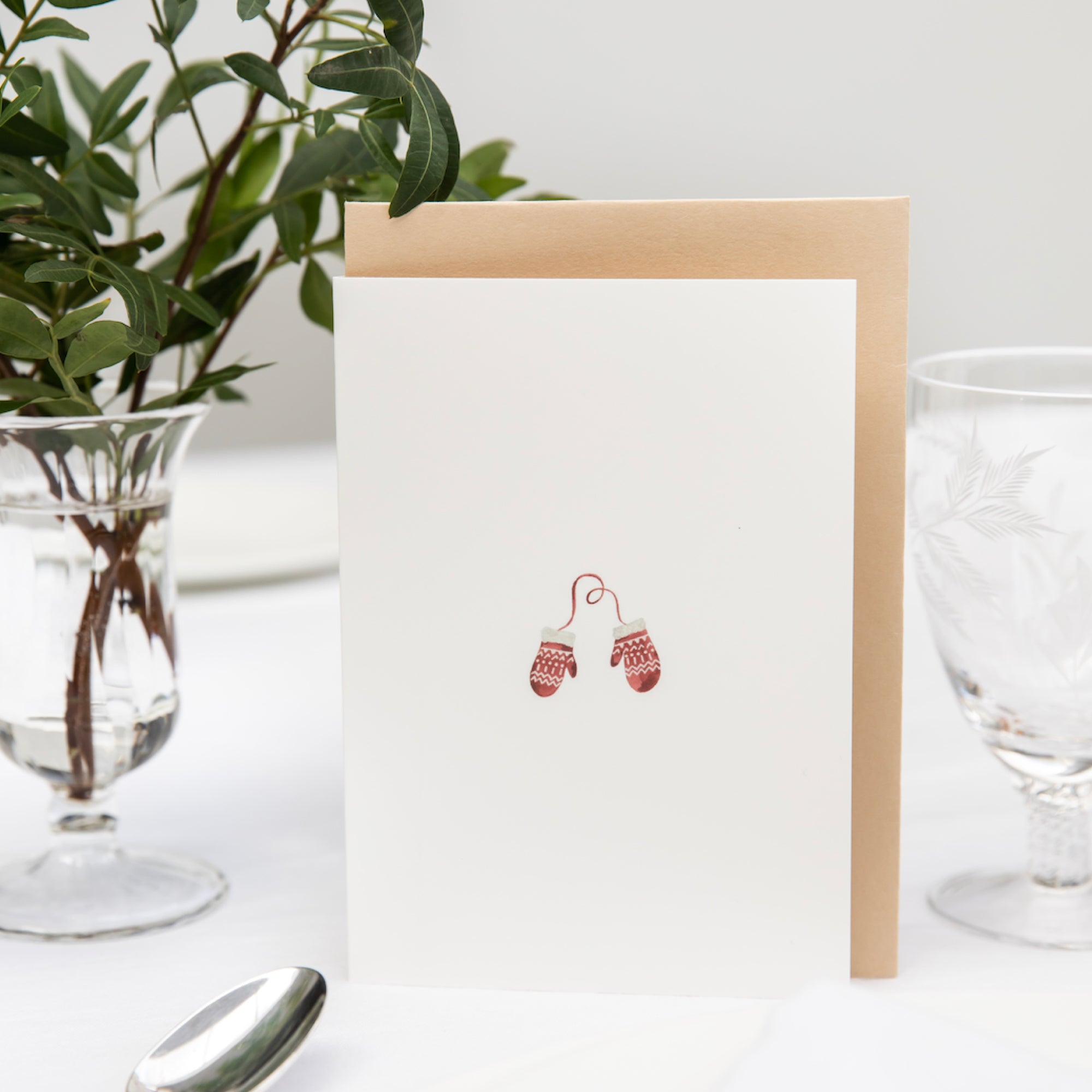 Luxury Christmas Card by Memo Press with a watercolour illustration of a pair of red and white mittens and comes with an oat envelope made in Britain