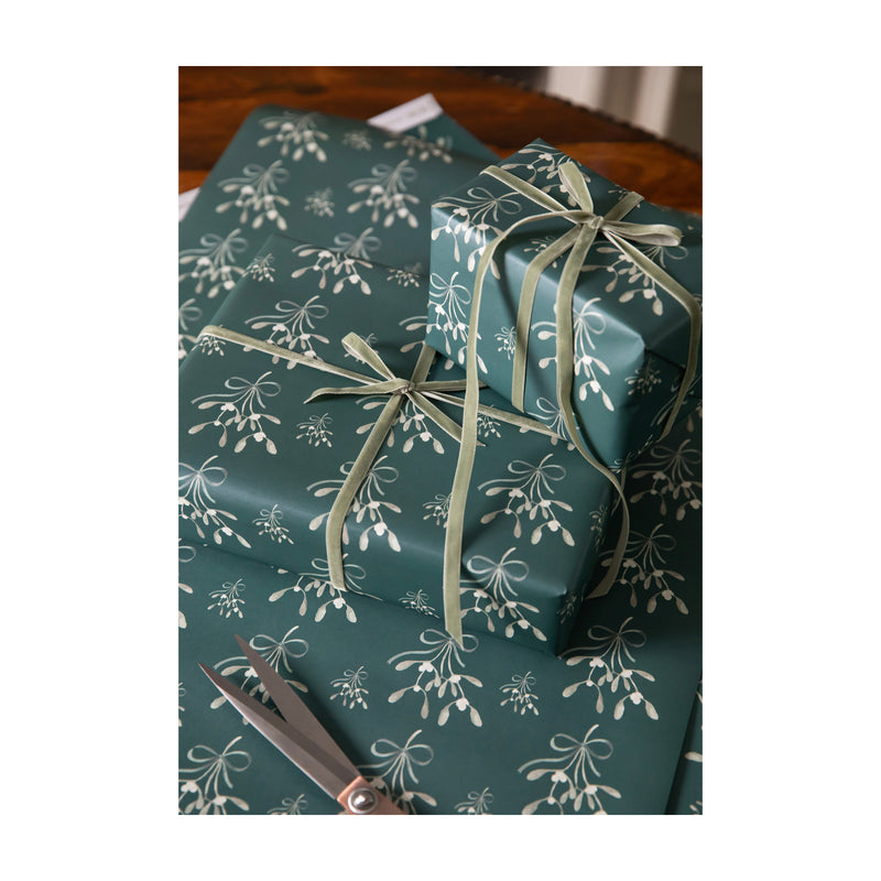Luxury Wrapping Paper for Christmas with watercolour illustrations of mistletoes tied with a velvet ribbon on green paper by Memo Press