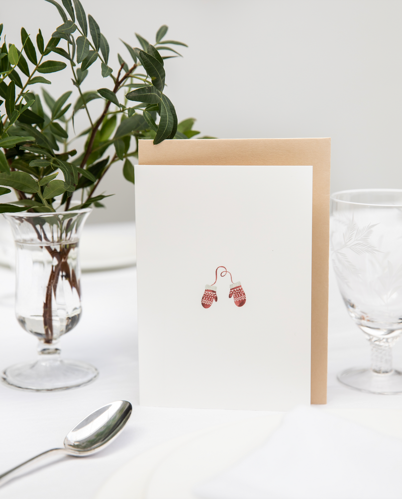 Luxury Christmas Card by Memo Press with a watercolour illustration of a pair of red and white mittens and comes with an oat envelope made in Britain
